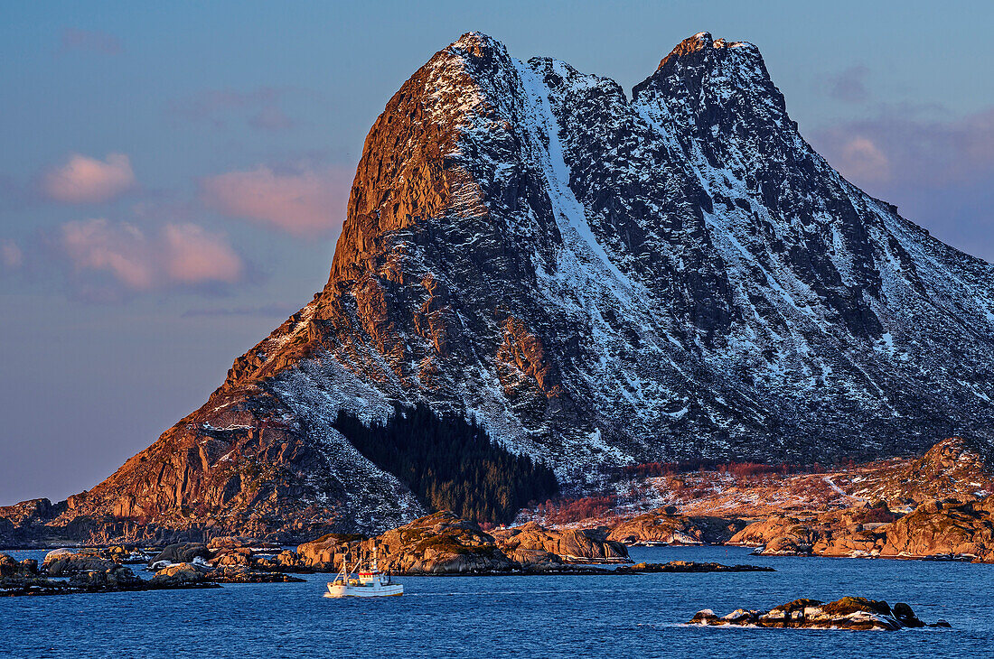 Ship sailing in front of snow-covered mountains, Lofoten, Nordland, Norway