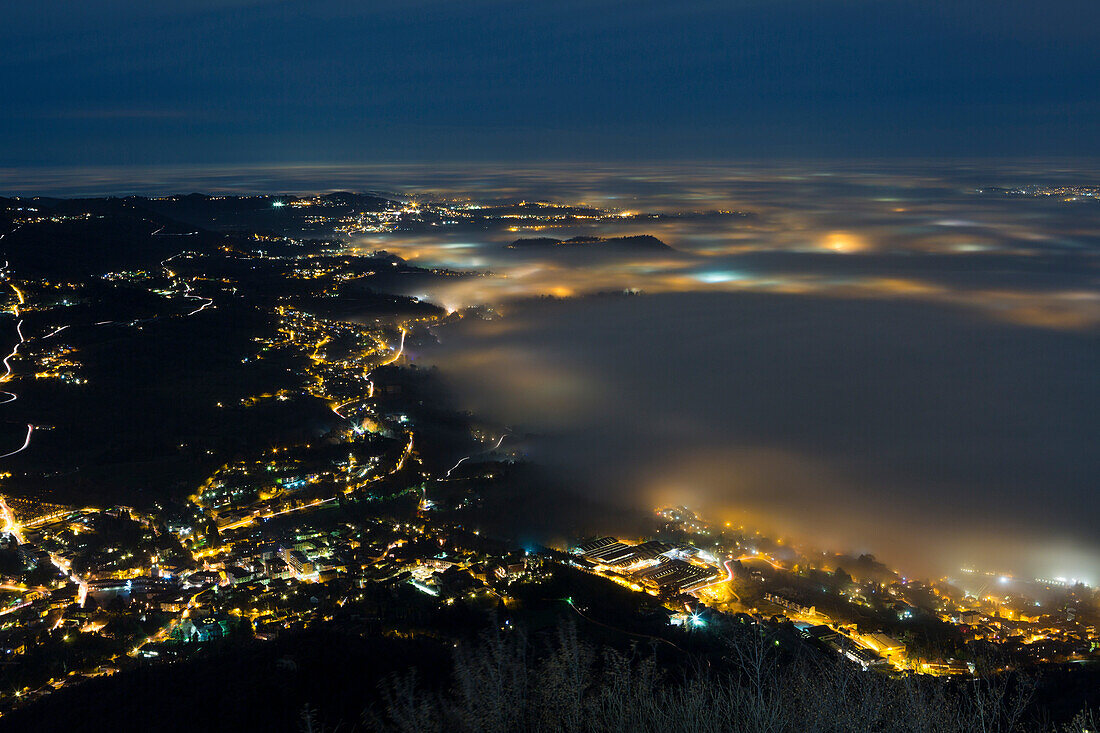 fog bank above Annone lake viewed from the top of Barro mount at dusk, Barro mount Regional Park, Lecco province, Lombardy, Italy