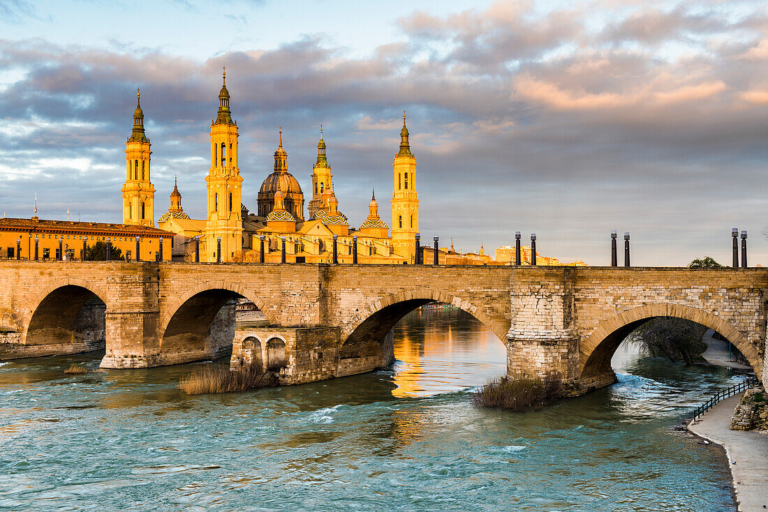 Cathedral of Our Lady of the Pillar and stone bridge at sunrise. Zaragoza, Aragon, Spain, Europe
