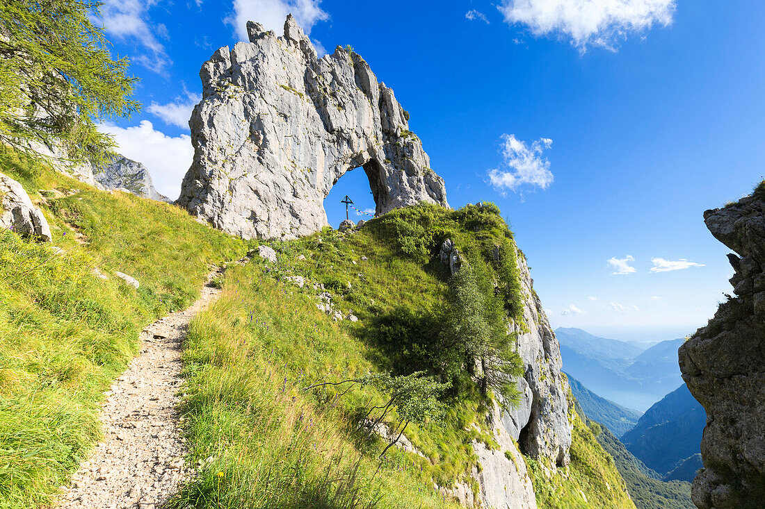A path leads to Porta di Prada, a rock natural arch in the Grigna group. Grigna Settentrionale(Grignone), Northern Grigna Regional Park, Lombardy, Italy, Europe.