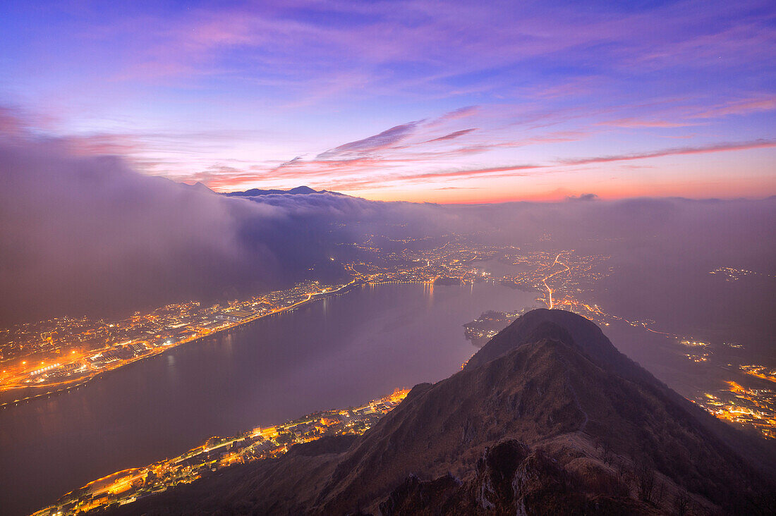 Colored clouds and fog during twilight on the Garlate Lake from Monte Barro, Monte Barro Regional Park, Brianza, Lombardy, Italy, Europe.