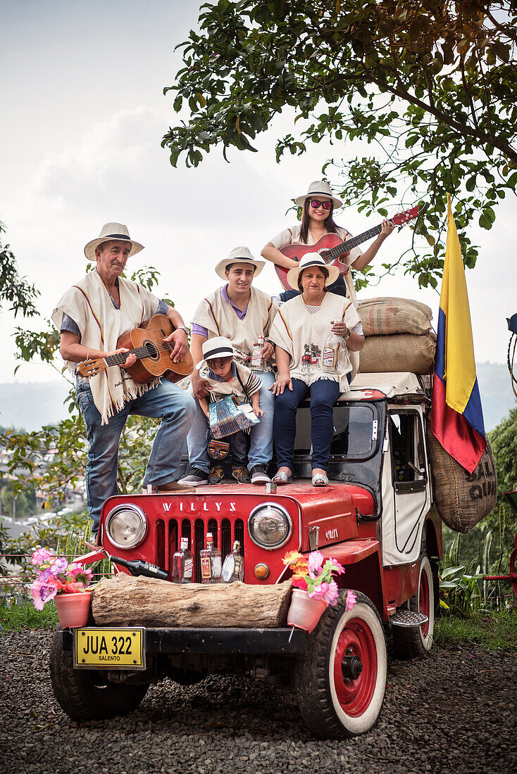 kolumbianische Familie posiert für ein Foto auf einem roten Geländewagen, Salento, UNESCO Welterbe Kaffee Dreieck (Zona Cafatera), Departmento Quindio, Kolumbien, Südamerika