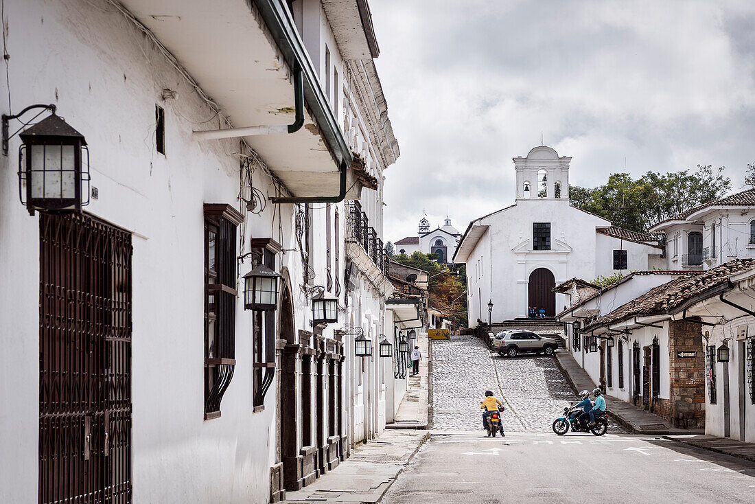 mehrere kleine Kirchen, koloniale Häuser und Motorradfahrer, Popayan, Departmento de Cauca, Kolumbien, Südamerika