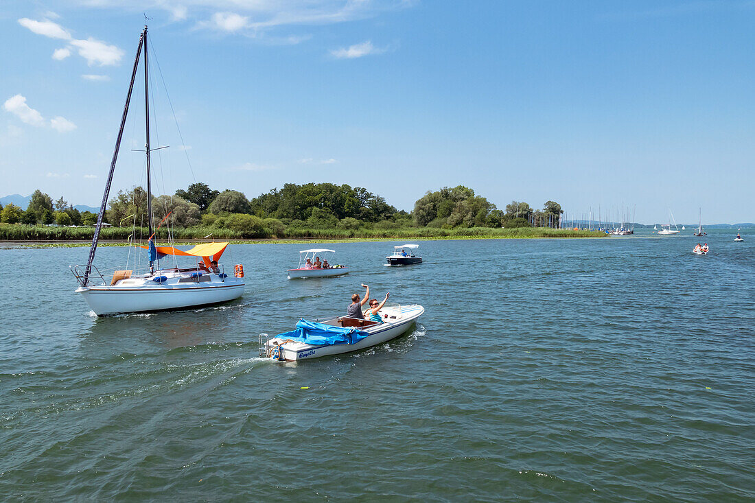 Sailing and electric boats on the Chiemsee in field