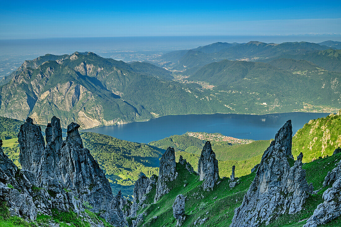 Rock spires with lake lago di Como in background, Grignetta, Grigna, Bergamasque Alps, Lombardy, Italy