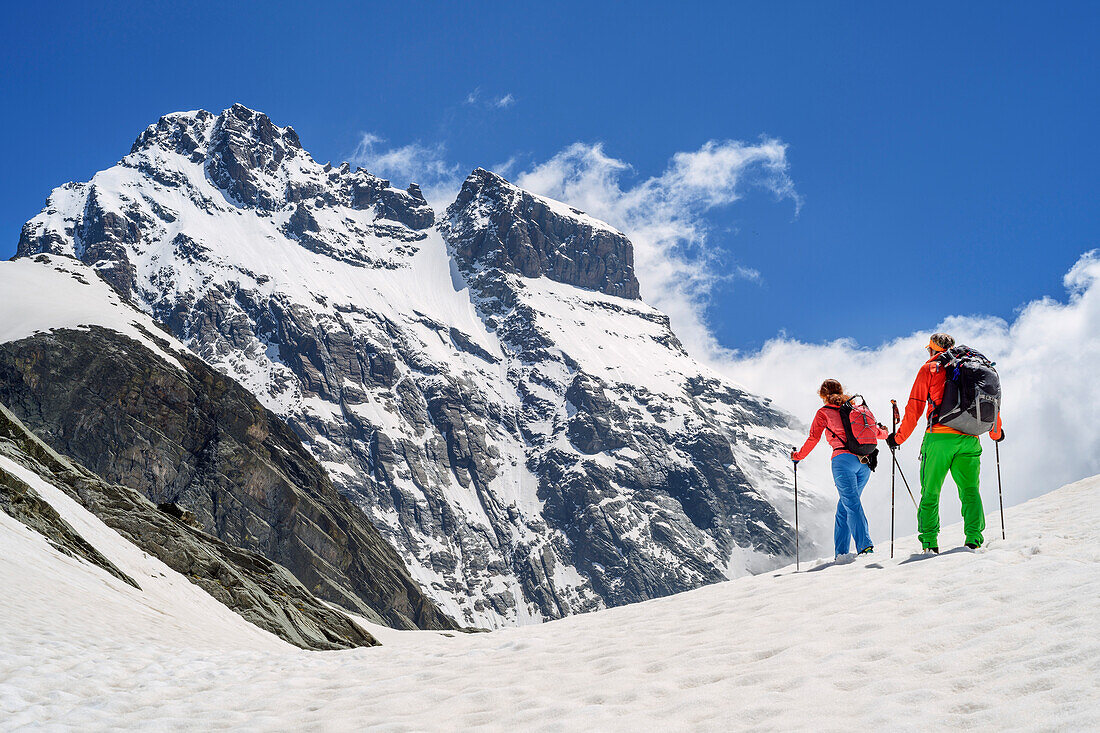 Man and woman hiking ascending through snow at Giro di Monviso towards Monviso, Giro di Monviso, Monte Viso, Monviso, Cottian Alps, France