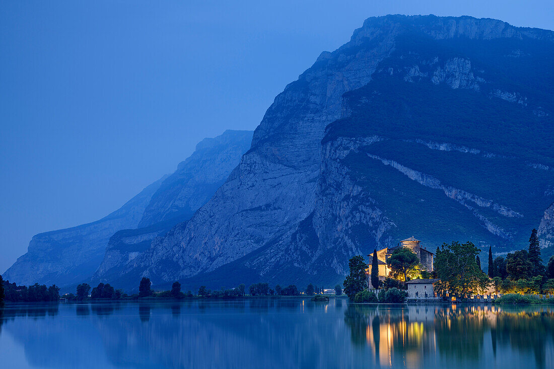 See Lago Toblino mit beleuchteter Burg Castello Toblino und Monte Casale im Hintergrund, Lago Toblino, Gardaseeberg, Trentino, Italien