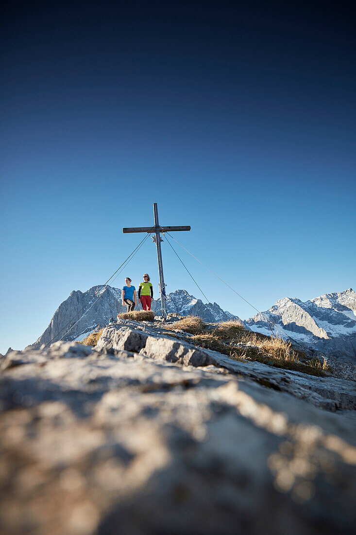 two women on Hahnkampl peak  Lamsenspitze in the back ,  Eastern Karwendel Range, Tyrol, Austria