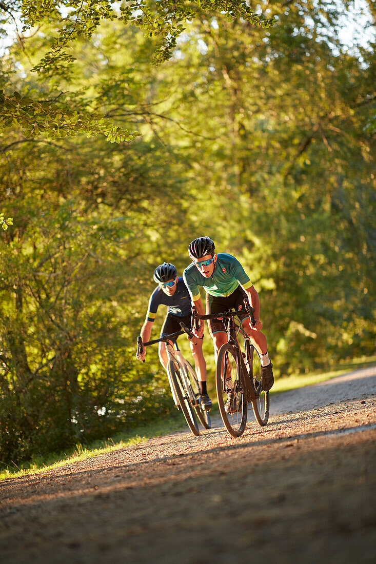 Zwei junge Männer fahren auf Gravel bikes über Feldweg, Münsing, Bayern, Deutschland