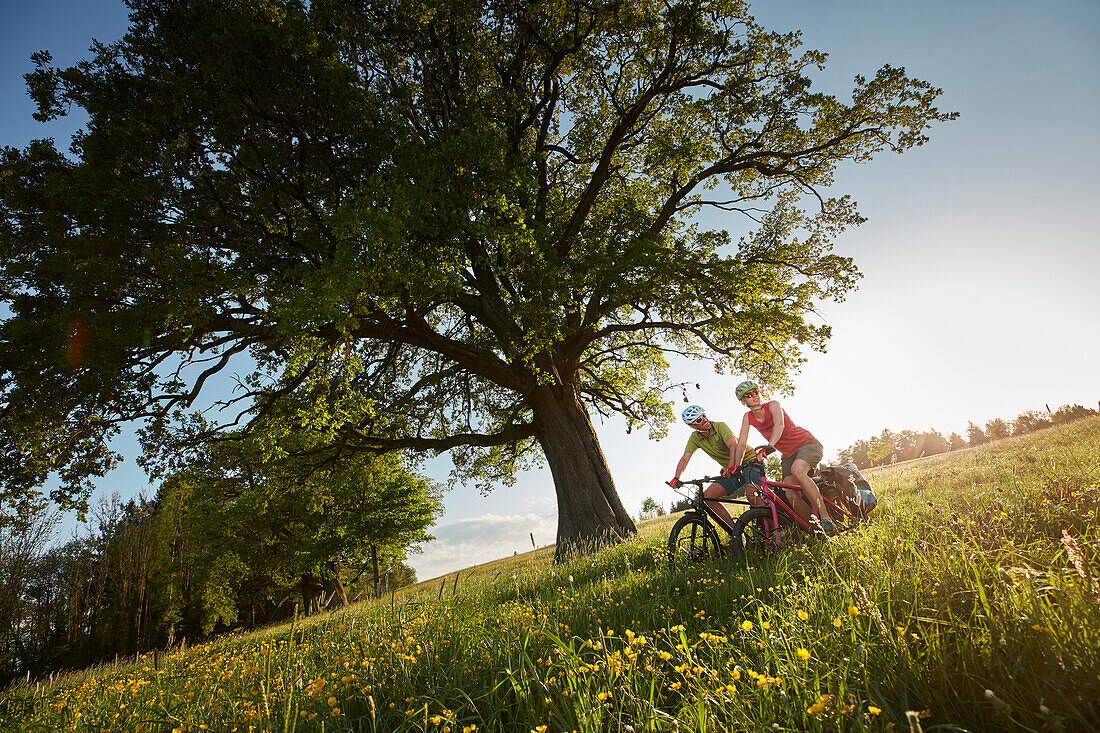 Young  woman young man on bicycle tour, Eurasburg, bavaria, germany