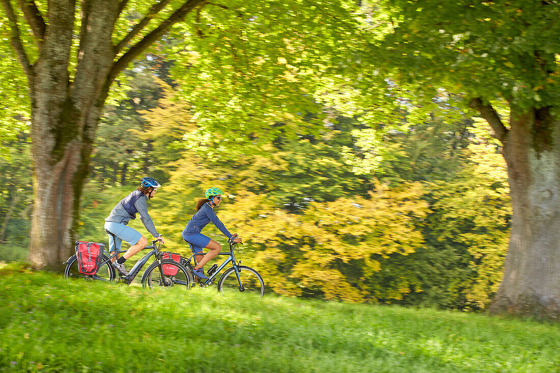 junge Frau auf Tourenrad und junger Mann auf eTourenfahrrad, Radtour, Münsing, Bayern, Deutschland