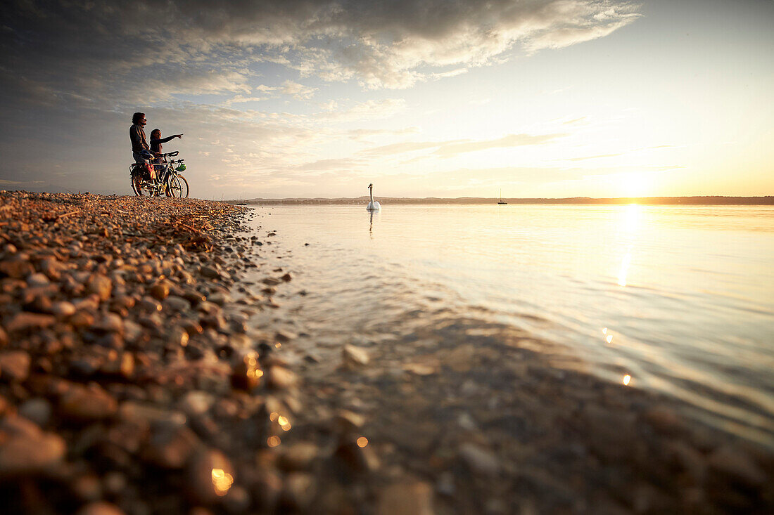 junge Frau auf Tourenrad und junger Mann auf eTourenfahrrad, Radtour am See, Münsing, Starnberger See, Bayern, Deutschland