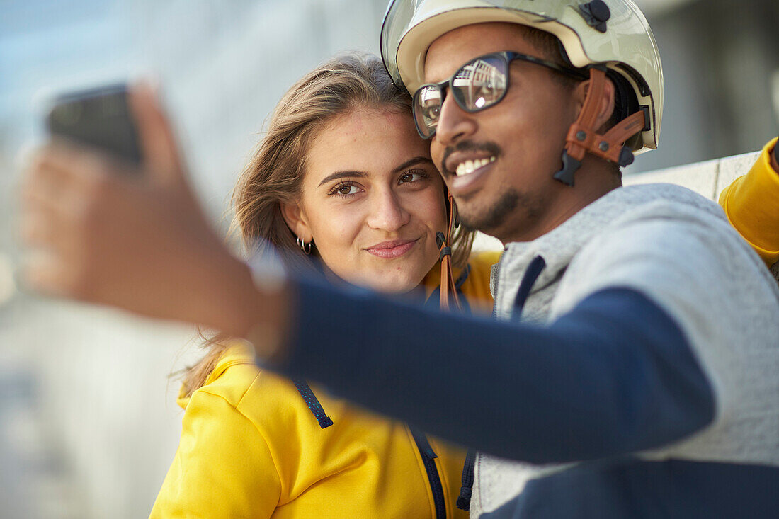 Young  woman young man on eBikes downtown taking Selfie, Munich, bavaria, germany