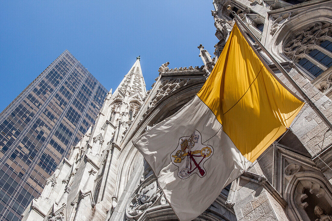 vatican flag with the spires of saint patrick's cathedral in the background, midtown manhattan, new york city, new york, united states, usa
