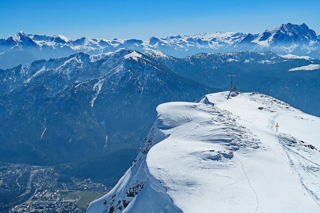 Person auf Skitour steht am Gipfel des Zwiesel, Tiefblick auf Bad Reichenhall, Zwiesel, Chiemgauer Alpen, Chiemgau, Oberbayern, Bayern, Deutschland