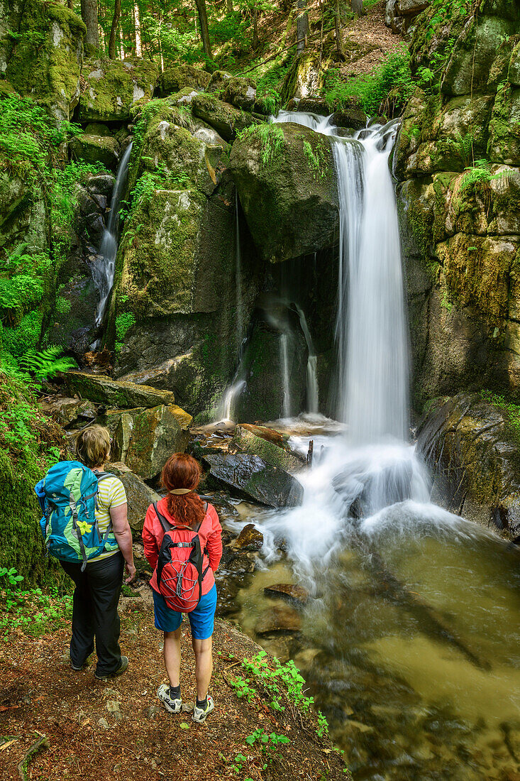 Zwei Frauen beim Wandern blicken auf Wasserfall, Höllbach-Wasserfall, Albsteig, Schwarzwald, Baden-Württemberg, Deutschland