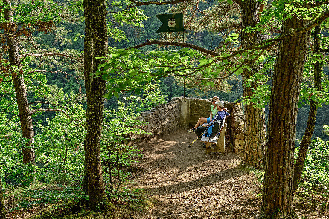 Man and woman sitting at vista-point in forest, Peterskanzel, Albsteig, Black Forest, Baden-Wuerttemberg, Germany