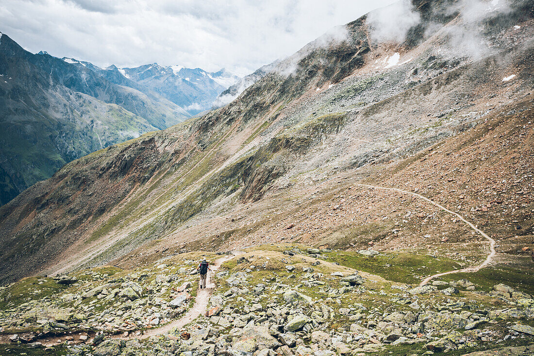 Climber passes boulder field on long distance hiking trail, E5,Alpenüberquerung,5th stage, Braunschweiger Hütte,Ötztal, Rettenbachferner, Tiefenbachferner, Panoramaweg to Vent, tyrol, austria, Alps