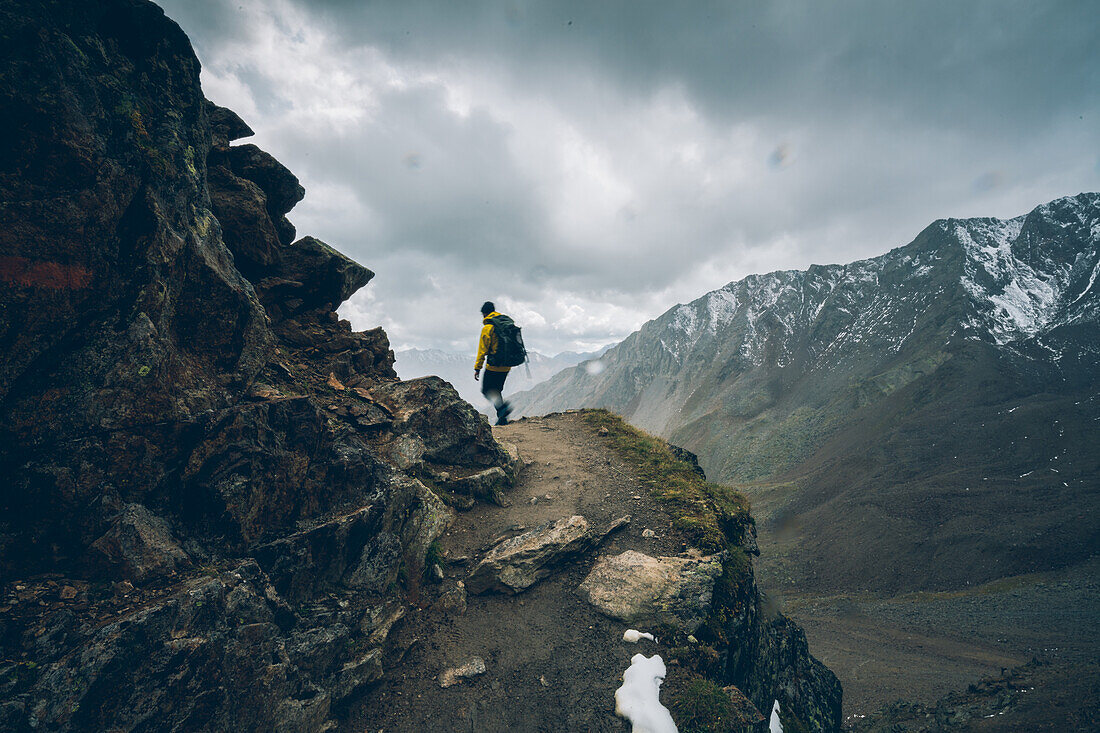 Climber climbing in bad weather, E5, Alpenüberquerung, 6th stage, Vent,Niederjochbach, Similaun hut, Schnalstal, Vernagt reservoir, Meran