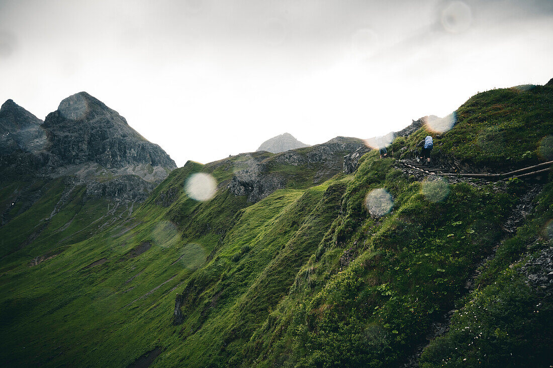 Bergsteiger beim Aufstieg im Regenschauer, E5, Alpenüberquerung, 1. Etappe Sperbachtobel, Kemptner Hütte, Allgäu, Deutschland