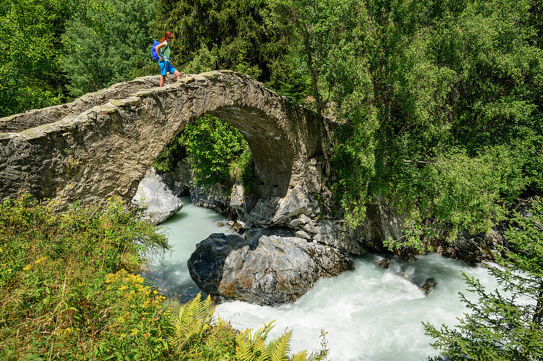 Frau geht über römische Steinbrücke Pont de Raya, Refuge de la Lavey, Ecrins, Nationalpark Ecrins, Dauphine, Dauphiné, Hautes Alpes, Frankreich