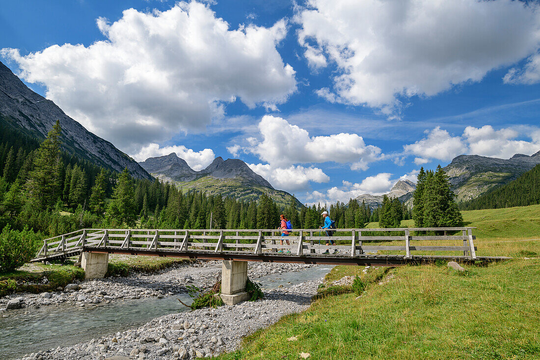 Mann und Frau wandern auf Brücke über den Lech, Lechweg, Lechquellengebirge, Vorarlberg, Österreich