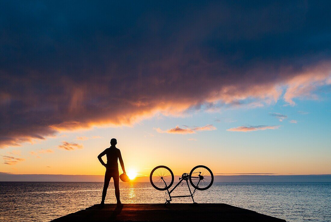 Seaton Carew, County Durham, north east England. United Kingdom. A mountain biker looks out over the North sea at sunrise.