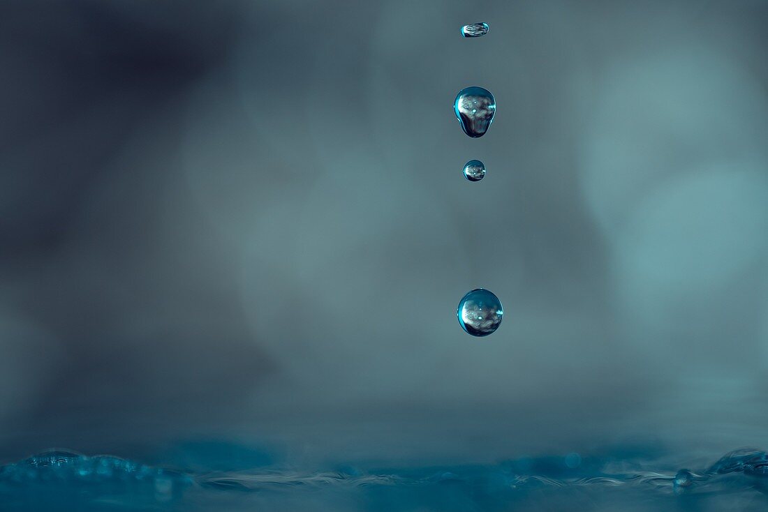 Drops of water falling towards the surface blue color