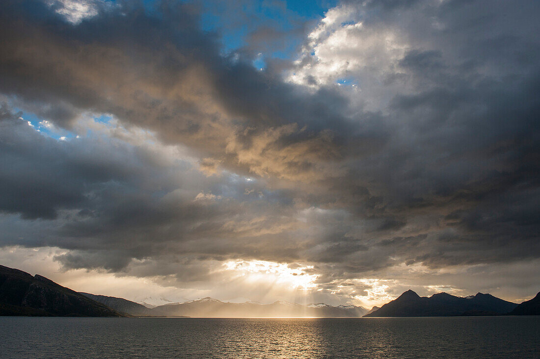 Sun breaks through cloud-cover off the Chilean coast, Beagle Canal, Alberto de Agostini National Park, Magallanes y de la Antartica Chilena, Patagonia, Chile, South America