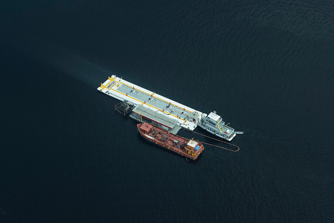 Aerial of two ships docked next to a gasoline station in the middle of the Rio Negro, a major tributary of the Amazon River, Manaus, Amazonas, Brazil, South America