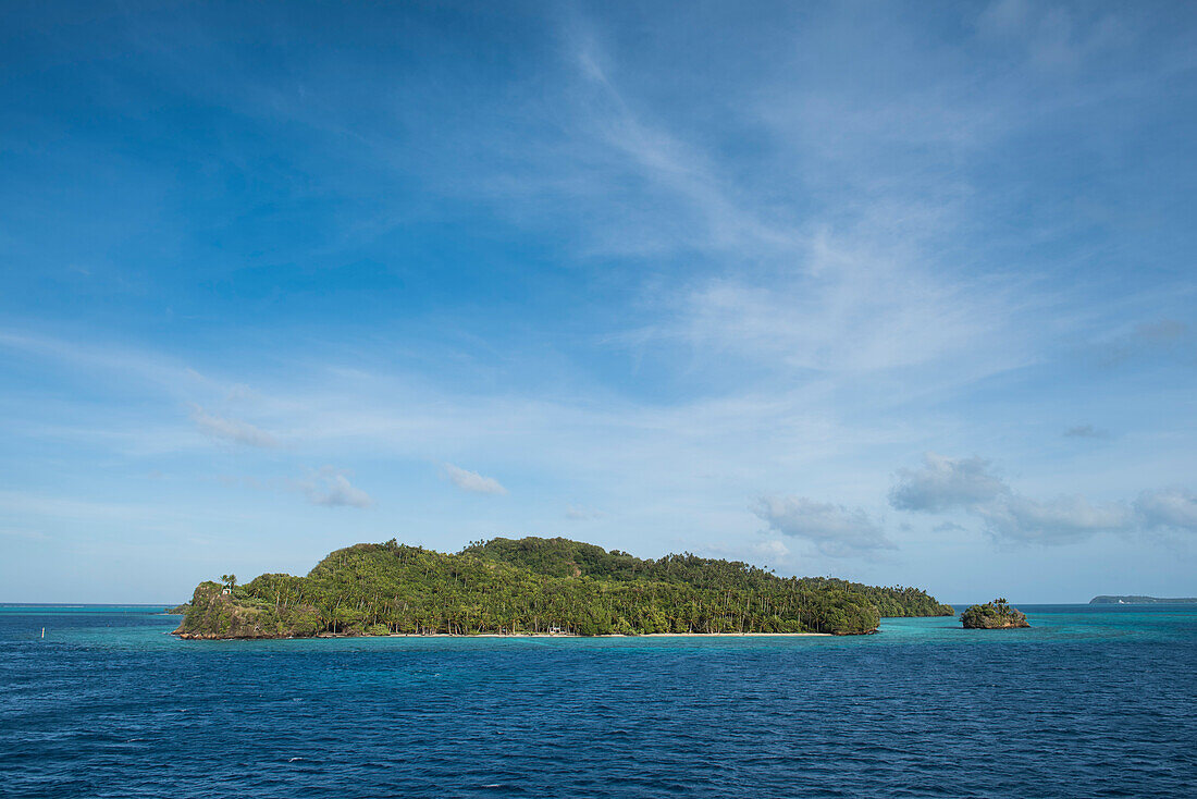 Kleine, baumbewachsene Inseln stehen im türkisfarbenen Wasser unter einem leicht bewölkten, blauen Himmel, Mata Utu, Uvea Island, Wallis und Futuna, Südpazifik