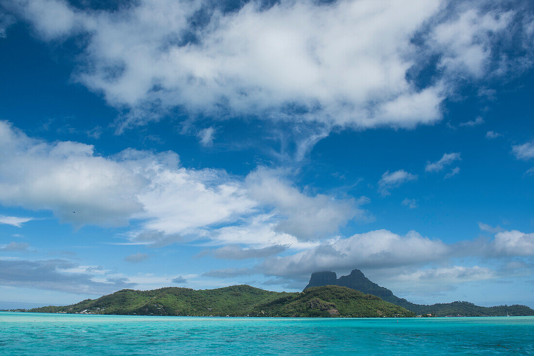 Blick auf Wolkenhimmel über der grünen Insel, Bora Bora, Gesellschaftsinseln, Französisch-Polynesien, Südpazifik
