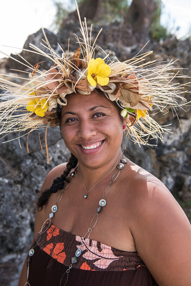 A local woman wearing a headdress of flowers and other plant material smiles at the viewer, Rimatara, Austral Islands, French Polynesia, South Pacific