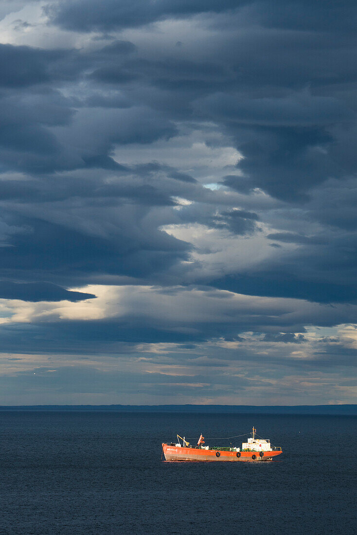 Das Schiff Brecknock fährt unter einem dominierenden Himmel aus dunklen, ungewöhnlichen Wolken, Punta Arenas, Magallanes y de la Antartica Chilena, Patagonien, Chile, Südamerika