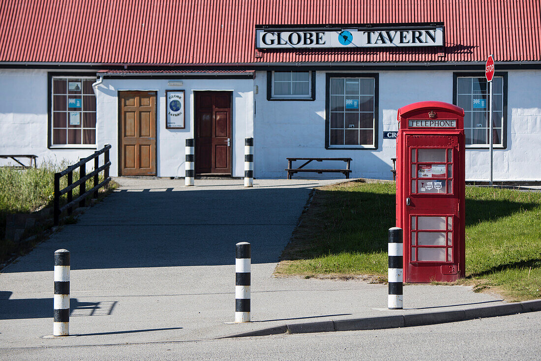 A typical red telephone booth stands in front of the Globe Tavern, one of the capital city's tourist attractions, Stanley, East Falkland, Falkland Islands, British Overseas Territory, South America