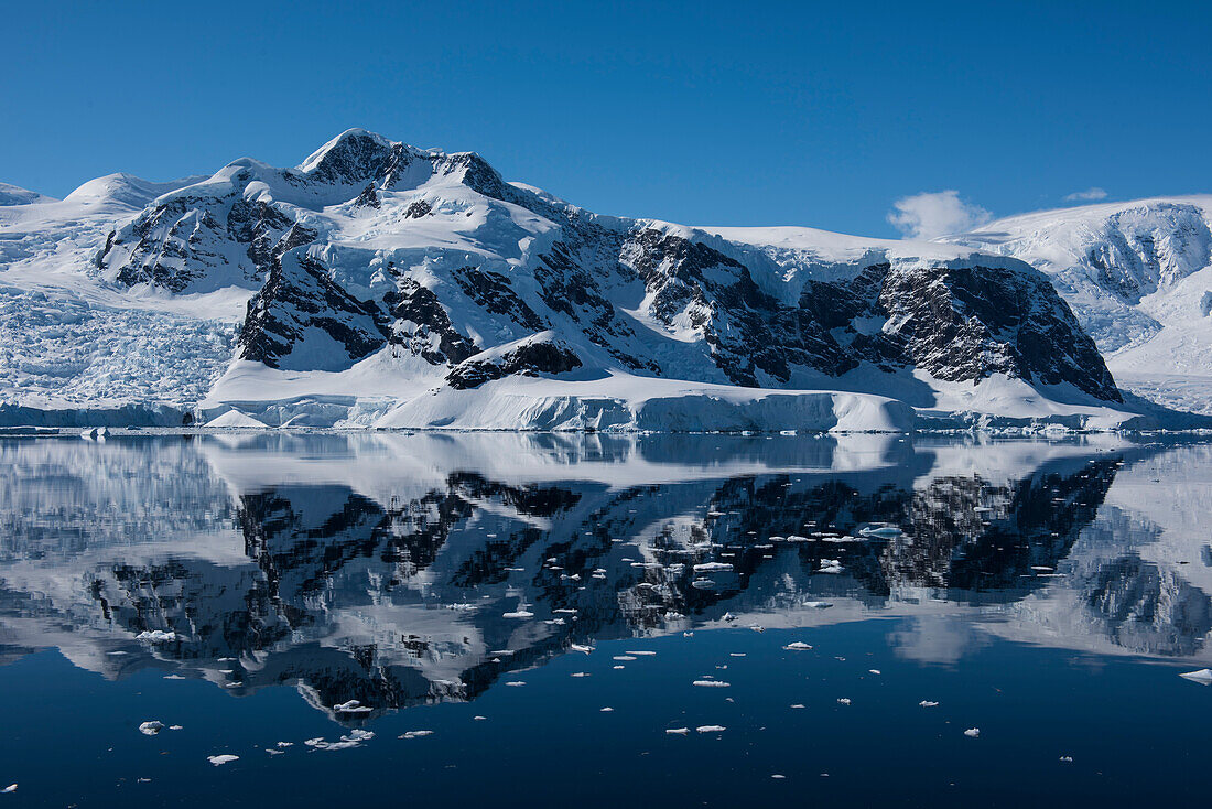 A rare, windstill moment allows the formation of an almost perfect mirror image of a wide mountain, Wilhelmina Bay, Antarctic Peninsula, Antarctica