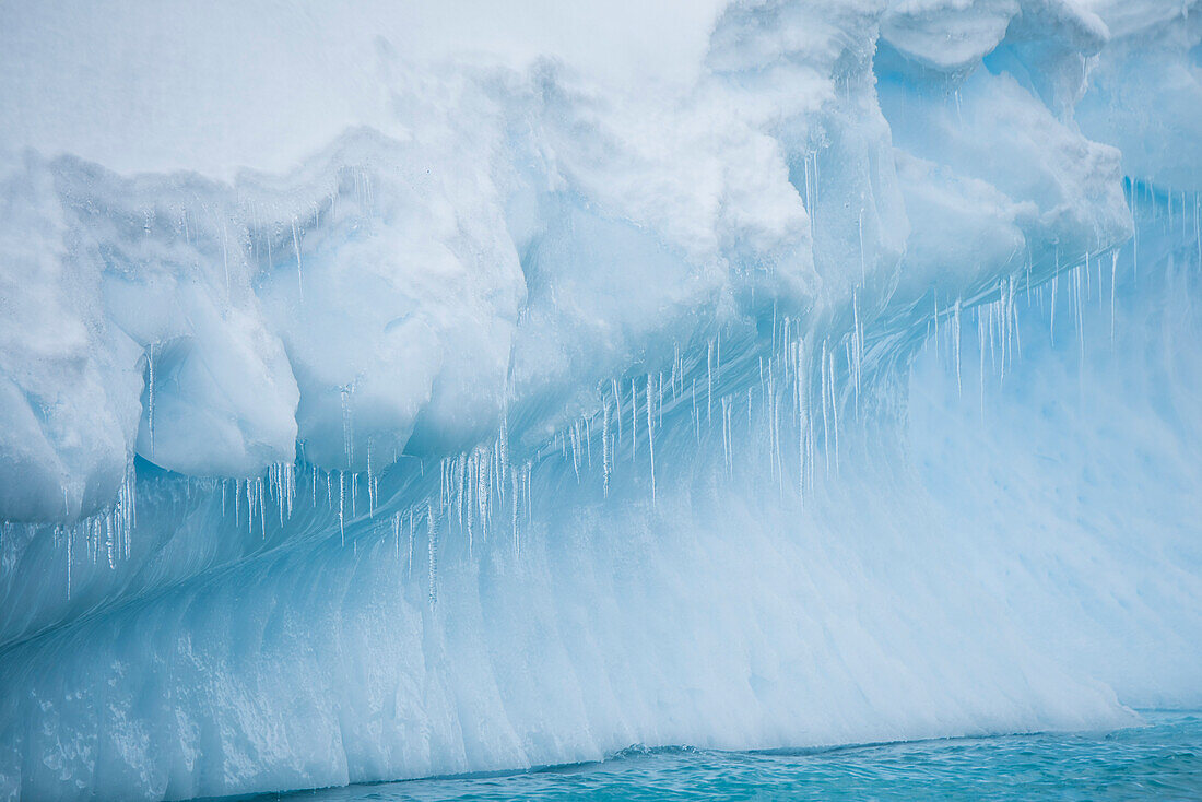 Numerous thin icicles form at the edge of a large iceberg, Dorian Bay, Wiencke Island, Antarctica