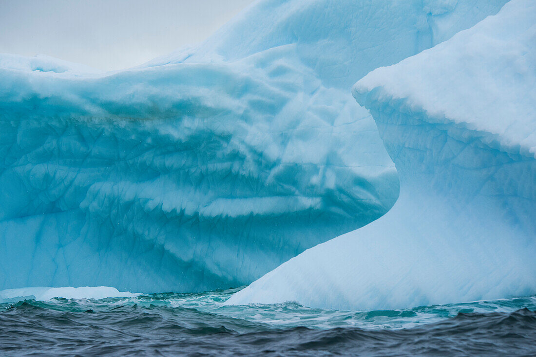 Blautöne von einem Eisberg im dunklen Meer schaffen eine abstrakte Ansicht, Melchior Island, Südliche Shetlandinseln, Antarktis