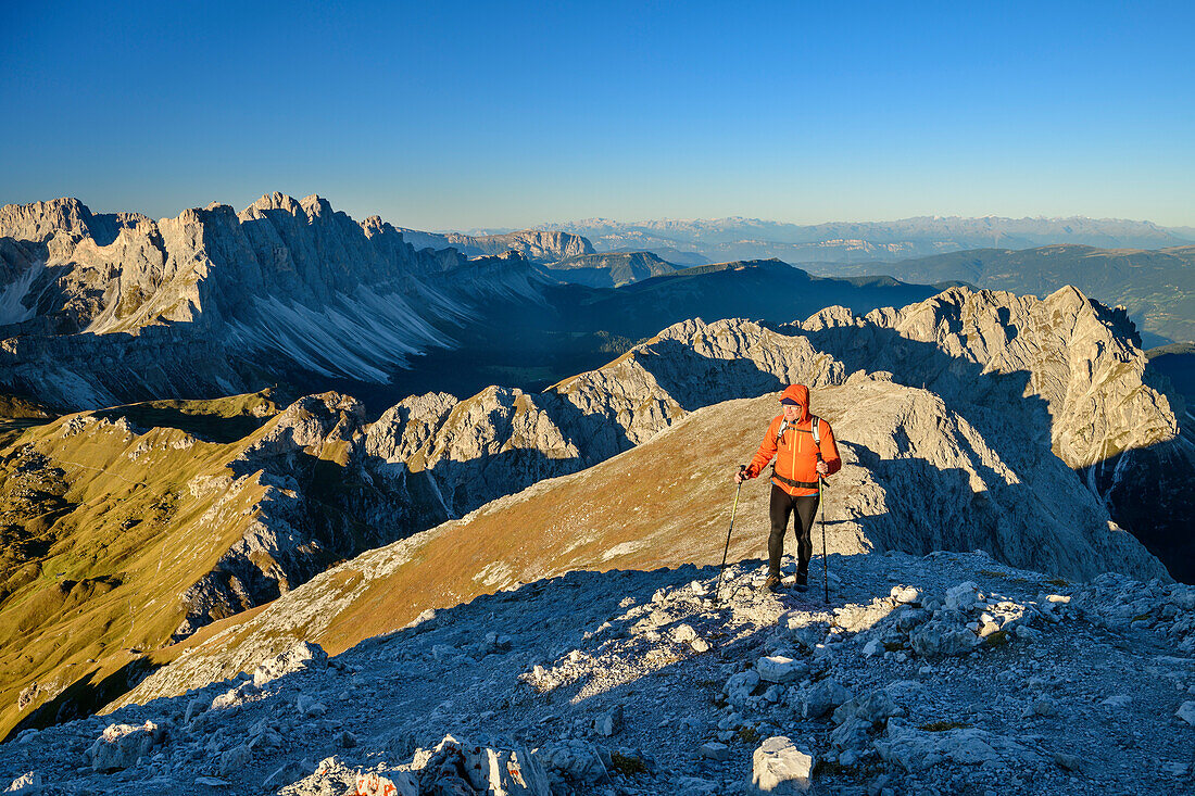 Mann beim Wandern steigt zum Peitlerkofel auf, Geislergruppe im Hintergrund, Peitlerkofel, Dolomiten, UNESCO Welterbe Dolomiten, Südtirol, Italien