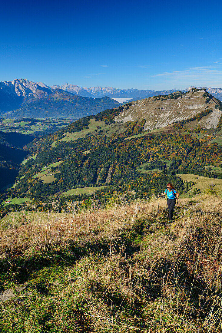 Woman hiking ascending towards Regenspitz, Berchtesgaden Alps and Schmittenstein in background, from Regenspitz, Salzkammergut, Salzburg, Austria