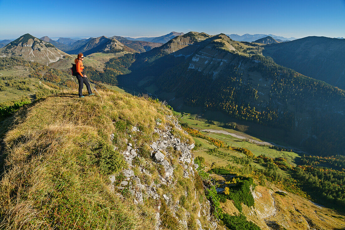 Woman hiking looking towards the valley, Salzkammergut Mountains in background, from Hochwieskopf, Salzkammergut, Salzburg, Austria