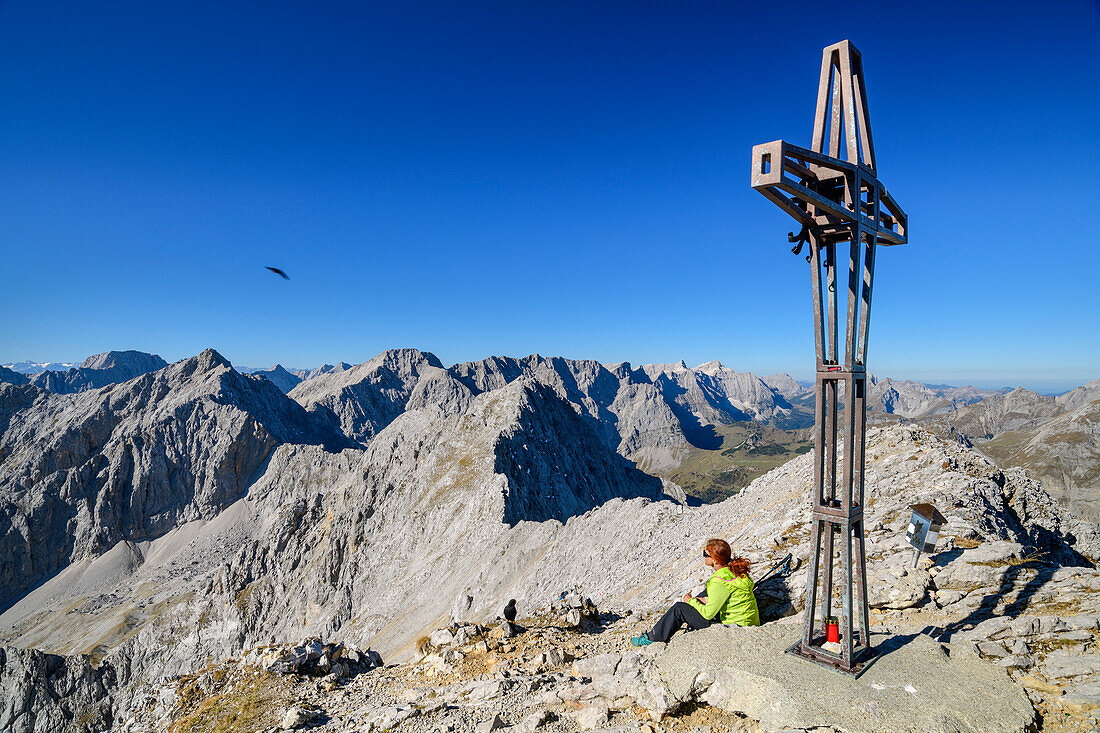 Frau beim Wandern sitzt am Gipfel der Lamsenspitze, Lamsenspitze, Naturpark Karwendel, Karwendel, Tirol, Österreich