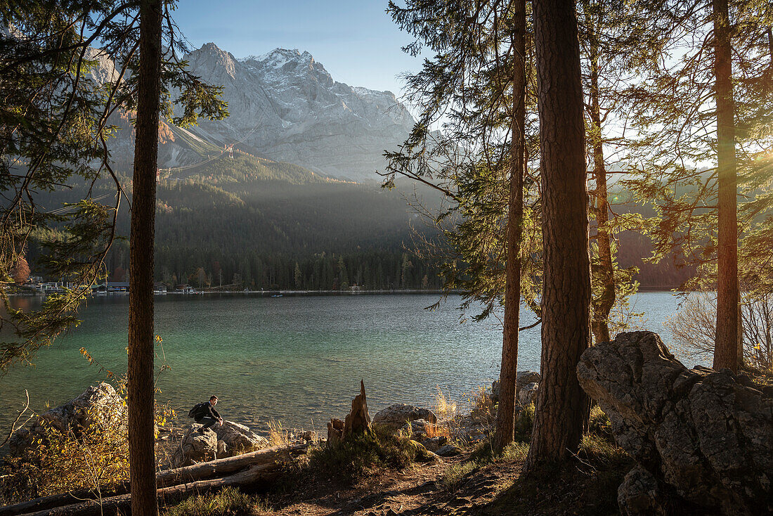 asian man enjoys view at Eibsee below Zugspitze mountain, Grainau community, Garmisch-Partenkirchen, Bavaria, Alps, Germany