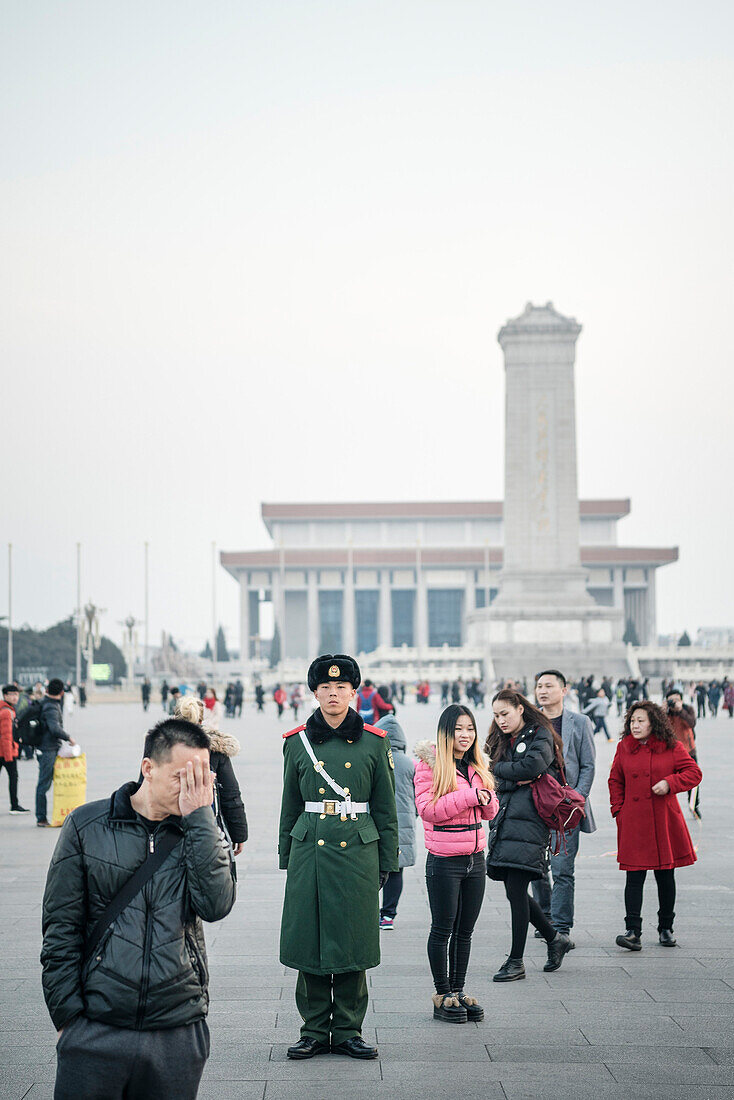 Wachmann steht vor Monument of the People’s Heroes und dem Mao Mausoleum umgeben von Besuchern still da, Platz des Himmlischen Friedens, Peking, China, Asien