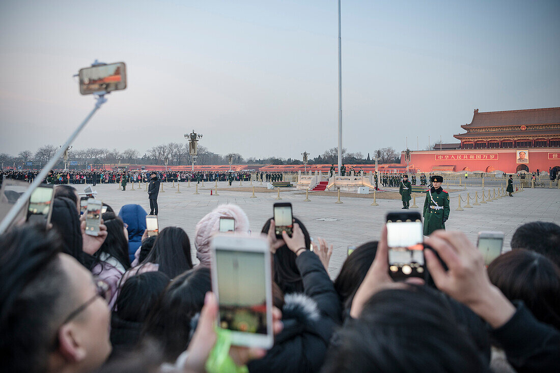 huge crowds of people photographing flag ceremony and  changing of the Guards at Tiananmen Square with their smartphones, Beijing, China, Asia
