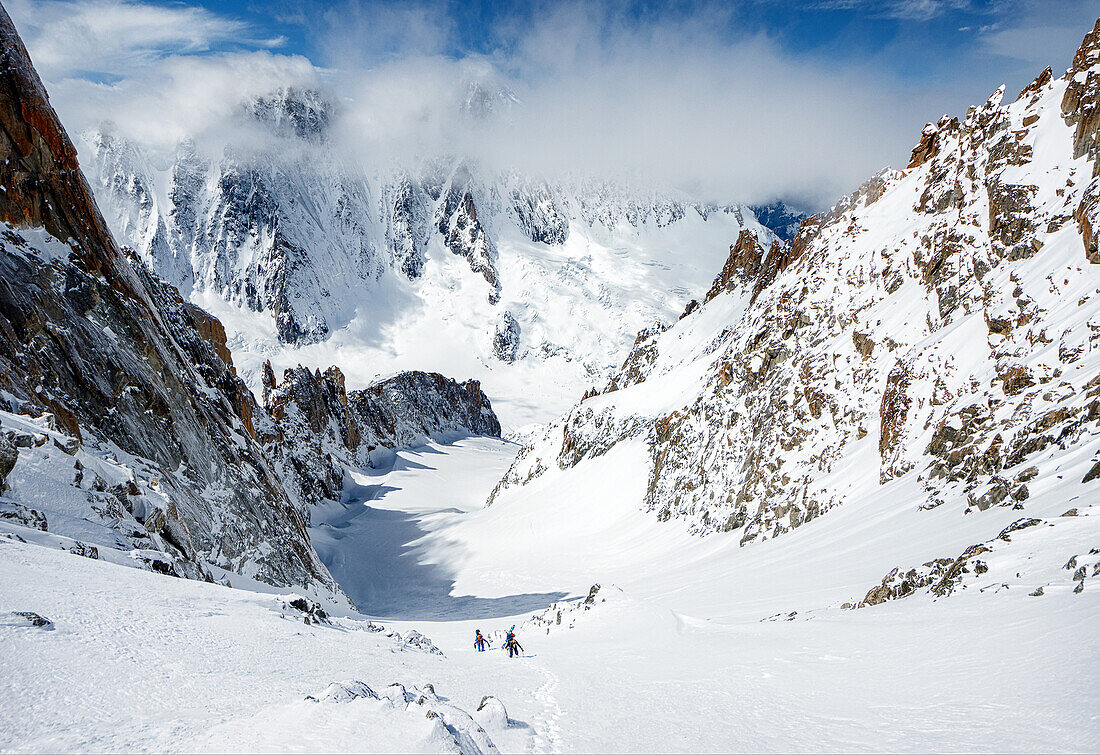 Two ski alpinists ascending towards the summit of Aiguille d'Argentière via the Glacier du Milieu, Chamonix, Haute-Savoie, France