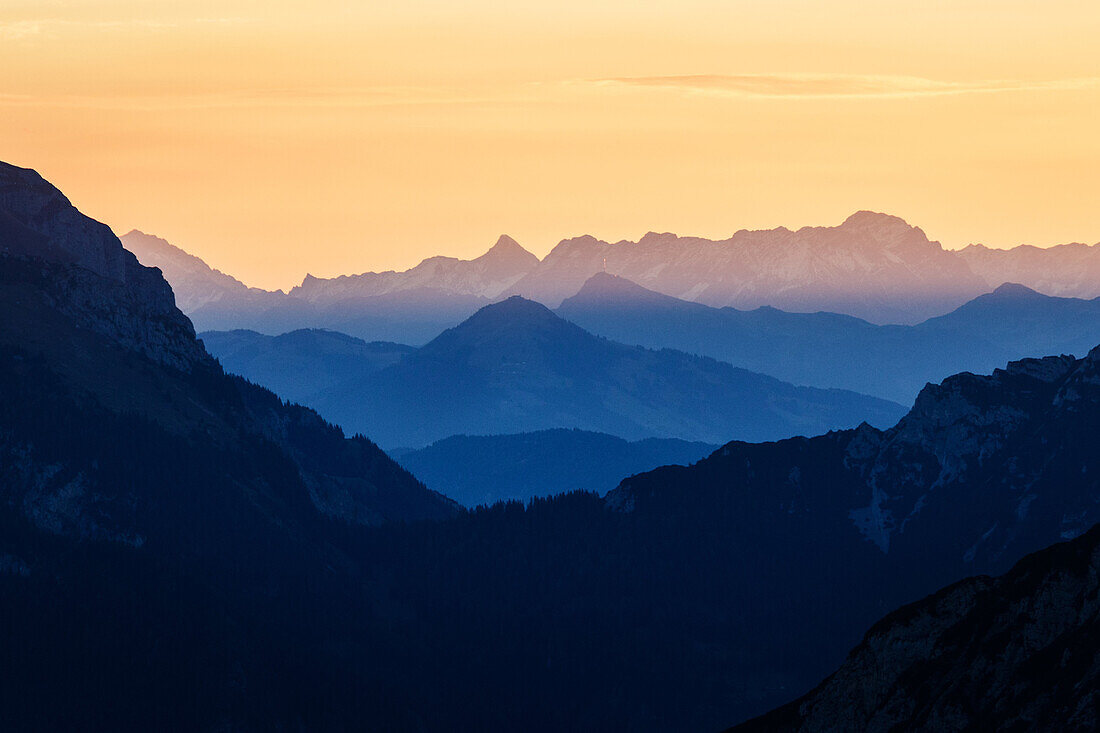mountain silhouettes in yellow and blue tones, sunrise, Karwendel, Tyrol, Austria