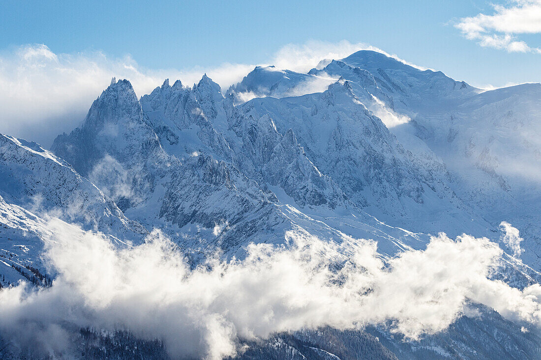 Summit of Mont Blanc mountain range during winter, clouds and fog, Aguille du Midi, Chamonix, Haute-Savoie, France