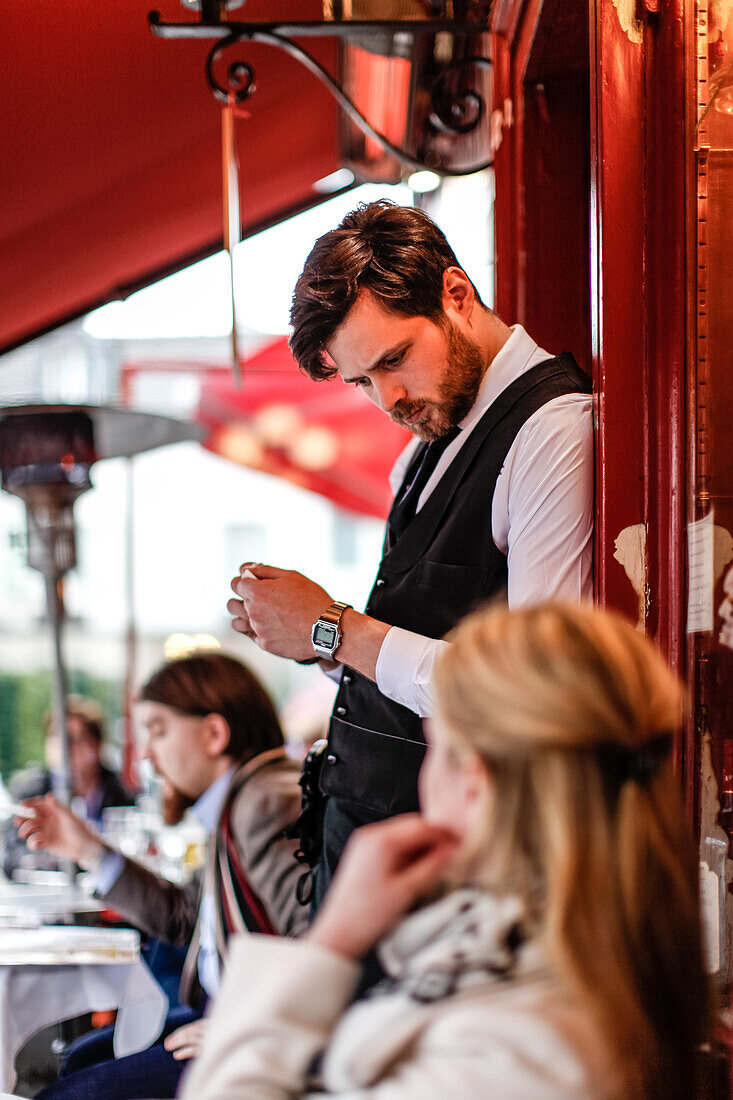 Kellner redet mit einer Touristin im La Mère Catherine Restaurant, Place du Tertre, Montmartre, Paris, Frankreich, Europa