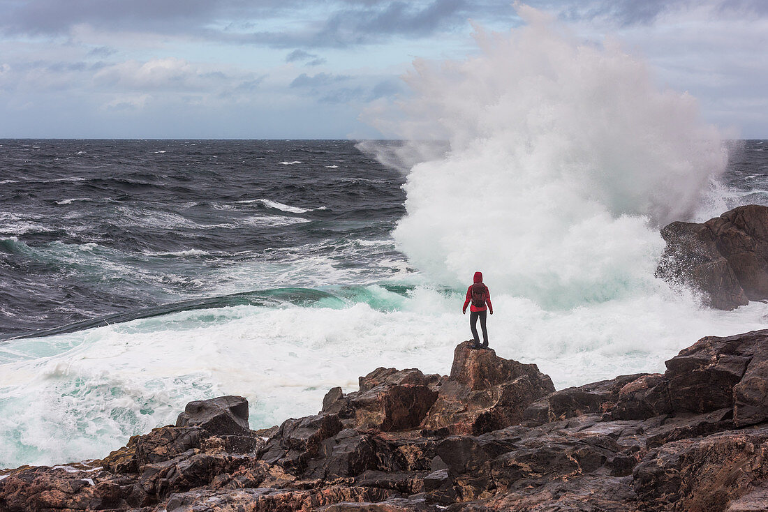 A woman faces the surf of the sea at Sheigra, Highlands, Scotland, United Kingdom